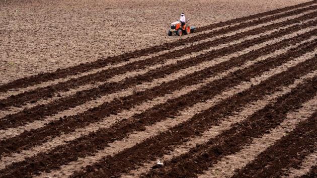 A farmer ploughs a field with a tractor near Prakasham Barrage in Vijayawada, Andhra Pradesh. (PTI) A farmer ploughs a field with a tractor near Prakasham Barrage in Vijayawada, Andhra Pradesh. (PTI)
