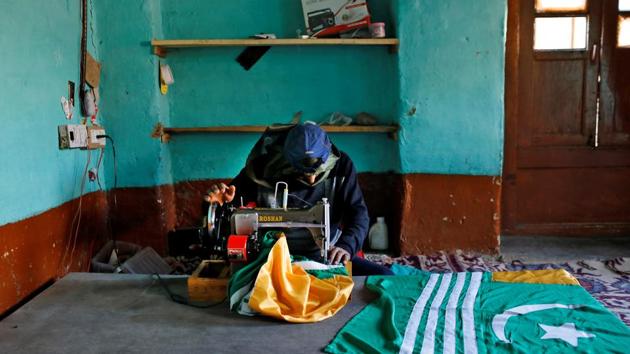 Mushtaq Wani, a 35-year-old tailor, sews Azad (Independent) Kashmir flags inside his house in Anchar neighbourhood during restrictions. "One solution. Gun Solution. Is the only English sentence my children know. We don't have any guns in this neighbourhood. What we have is the will to resist. By the will of Allah, our stones are more dangerous than their bullets. We will get freedom, or we will die," said Mushtaq. (Danish Siddiqui / REUTERS)