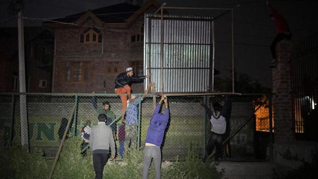 Men carry a tin shed to be used as a barricade to prevent security forces from entering Anchar neighbourhood. (Danish Siddiqui / REUTERS)