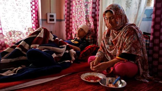 Irshad, a 15-year-old Kashmiri boy who was injured by pellets fired by Indian security forces while he was returning home from Friday prayers, rests as his mother Rubina cuts a fruit for him. The boy’s head is heavily bandaged and he hasn’t spoken since the incident, but the family would rather treat him at home than take him to a city hospital, fearing he would be detained by police. (Danish Siddiqui / REUTERS)