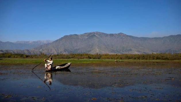 A man from Anchar neighbourhood catches fish in the waters of Anchar Lake during the restrictions. (Danish Siddiqui / REUTERS)