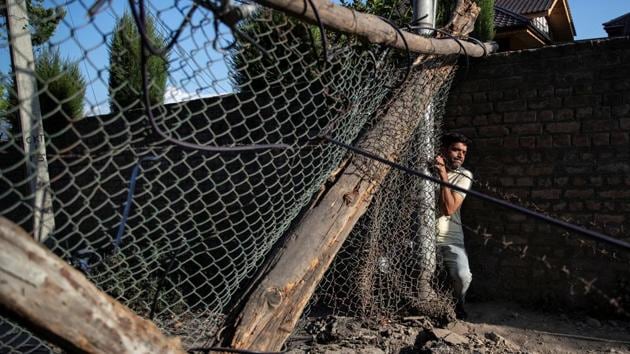 A man tries to pass through a barricade set up by residents to prevent Indian security forces from entering Anchar neighbourhood, during restrictions following the scrapping of the special constitutional status for Kashmir by the Modi government, in Srinagar, Jammu and Kashmir. Since the abrogation of Article 370, Anchar, a densely-populated, working class area in Srinagar, has emerged as a pocket of resistance against the central government’s move. (Danish Siddiqui / REUTERS)