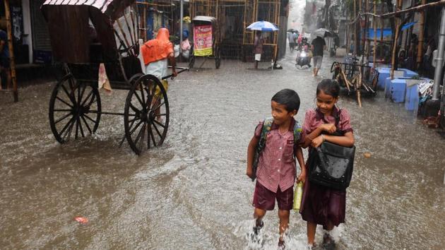 Children walk through a water-logged road during heavy rain in Kolkata, West Bengal. (Dibyangshu Sarkar / AFP) Children walk through a water-logged road during heavy rain in Kolkata, West Bengal. (Dibyangshu Sarkar / AFP)