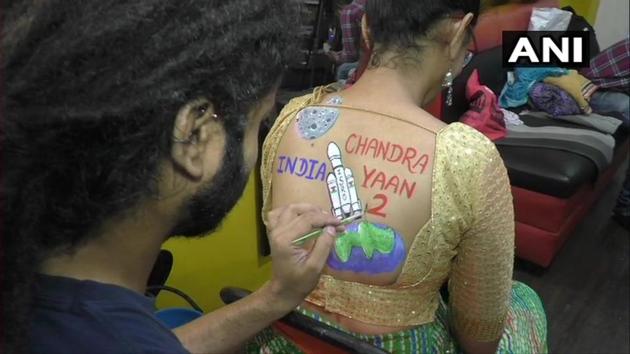 As a part of Navratri 2019 preparation, a woman is getting body paint tattoo.(Twitter/ANI)