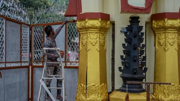 A worker seen painting a pillar at the Chatuhshrungi temple prior to Navratri.(Milind Saurkar/HT Photo)