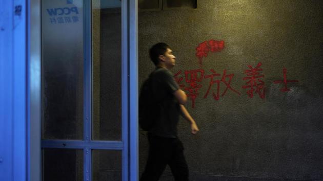 A man walks past a red anti-government graffiti reads in Chinese "Release righteous" outside a subway station in Hong Kong. It will be difficult to meticulously clean up the streets of Hong Kong, as is being done in Beijing, before China’s upcoming National Day celebration on Tuesday. (Vincent Yu / AP) A man walks past a red anti-government graffiti reads in Chinese "Release righteous" outside a subway station in Hong Kong. It will be difficult to meticulously clean up the streets of Hong Kong, as is being done in Beijing, before China’s upcoming National Day celebration on Tuesday. (Vincent Yu / AP)