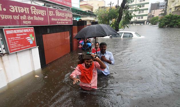 A patient along with his attendant and nursing staff waits for a rescue team to arrive on a flooded street in Patna. As many as 25 people have been killed in Bihar in the last 24 hours. (ani photo)