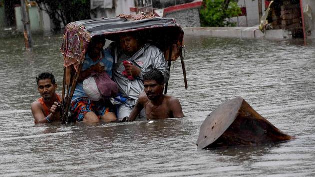 A rickshaw puller wades through a flooded street after heavy rainfall, in Patna.(ANI Photo)
