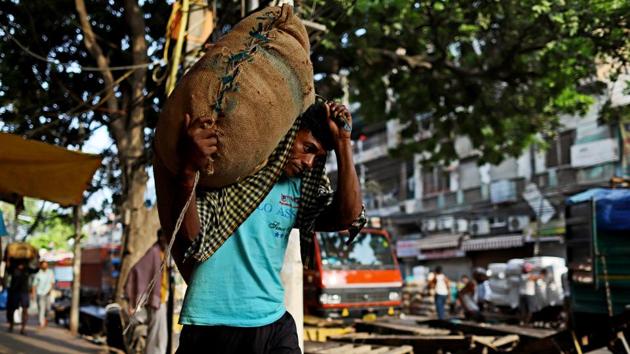 A worker carries a sack at a wholesale market in Delhi. The official said there will be extensive focus on promoting Apprenticeship training(Photo: Bloomberg)