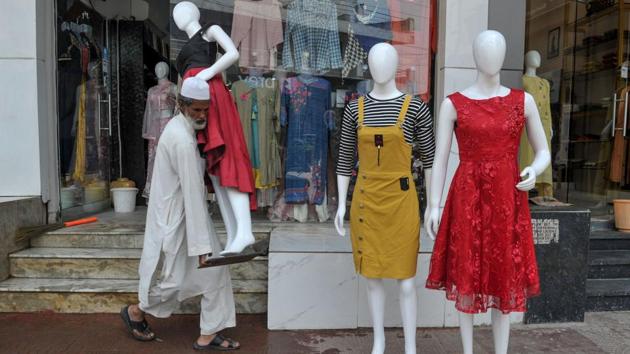 A vendor carries a mannequin outside a readymade sales shop. Economists are saying that a raft of recent government measures to revive the flagging economy, including a corporate tax cut, would improve sentiment in coming years. (Noah Seelam / AFP)