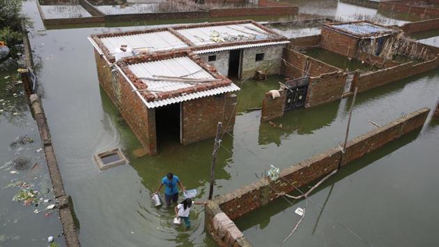 People wade through floodwaters in Prayagraj. Nearly 850 prisoners from Uttar Pradesh’s Ballia District Jail have been shifted to jails in the neighbouring districts following heavy water-logging inside the barracks after incessant rains since Wednesday. According to Ballia District Magistrate Bhavani Singh Khangaraut, “Waterlogging from five inches to one foot has been reported from all the barracks of the district jail. “ (Rajesh Kumar Singh / AP)