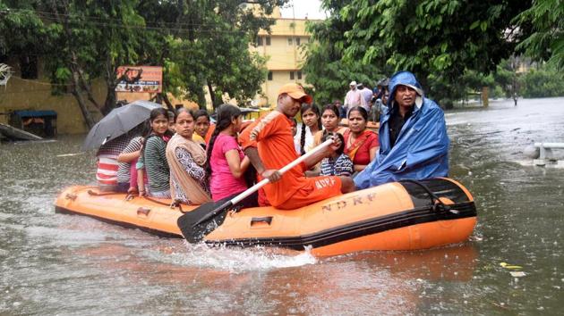 National Disaster Response Force (NDRF) workers rescue people from the flood-affected area of Bahadurpur in Patna. The state disaster response force has been deployed for rescue efforts and has installed additional pumps across the city to flush out water. Bihar’s principal secretary disaster management Pratyay Amrit said 15 districts where more rain is expected in the next 24 hours have been put on alert and all schools have been closed till Tuesday. (Santosh Kumar / HT Photo)