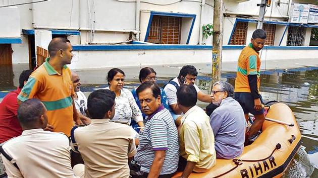 Bihar Deputy CM Sushil Kumar Modi (extreme right, in grey shirt) and his family members being rescued by a SDRF team from his flooded residence at Rajendra Nagar, in Patna.(PTI Photo)