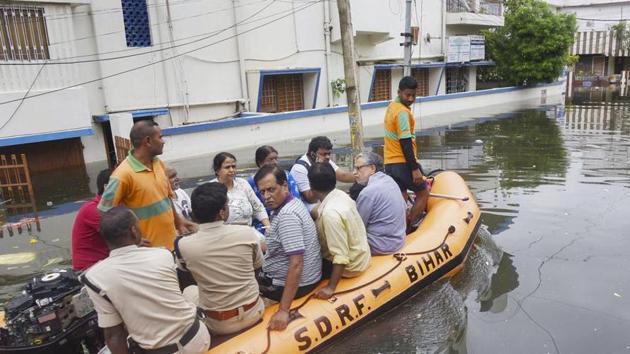 Bihar Deputy CM Sushil Kumar Modi (extreme right, in grey shirt) and his family members being rescued by a SDRF team from his flooded residence at Rajendra Nagar, in Patna.(PTI Photo)