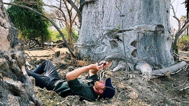 Prince Harry lying on the ground as he points his camera up towards the sky to capture a stunning still.(Instagram/natgeo)