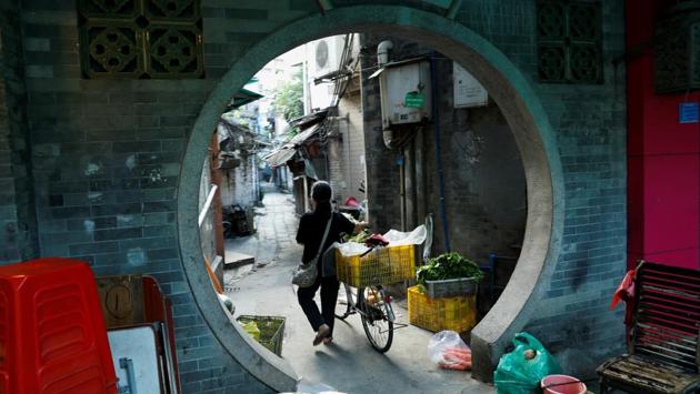 A woman pushes a bike in the city's old district of Liwan in Guanghzou. Life on the city’s fringes can be hard, with house prices among China’s highest and poorer elderly residents forced to sort rubbish to earn a living. (Jorge Silva / REUTERS)