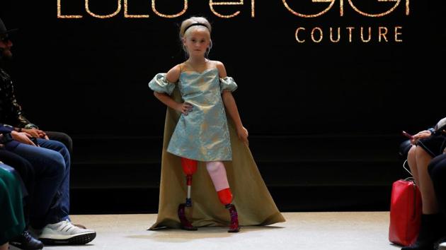 Daisy-May Demetre presents a creation by Designer Eni Hegedus-Buiron for luxury children’s wear label Lulu et Gigi during Paris Fashion Week inside Eiffel Tower, in Paris, France. Nine-year-old Demetre, whose legs were amputated due to a birth defect, became the first double amputee to walk the runway the prestigious show. (Gonzalo Fuentes / REUTERS)