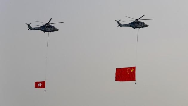Helicopters fly over with displaying the flag of China, right, and the flag of Hong Kong, in Hong Kong while the celebration of the People's Republic's 70th anniversary is taking place in Beijing. Police warned of the potential for protesters to engage in violence "one step closer to terrorism" during the week's National Day events, an assertion ridiculed by activists as propaganda meant to scare people from taking to the streets. (Vincent Thian / AP)
