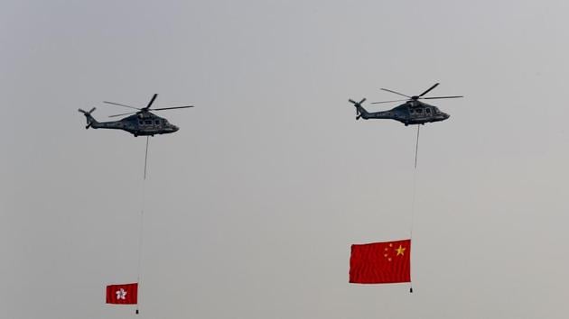Helicopters fly over with displaying the flag of China, right, and the flag of Hong Kong Tuesday, Oct. 1, 2019, in Hong Kong while the celebration of the People's Republic's 70th anniversary is taking place in Beijing. Police are warning of the potential for protesters to engage in violence "one step closer to terrorism" during this week's National Day events, an assertion ridiculed by activists as propaganda meant to scare people from taking to the streets.(AP)