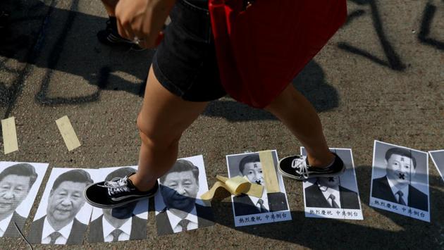 An anti-government protester steps on pictures of Chinese President Xi Jinping in Sham Shui Po district, on China’s National Day in Hong Kong, China. While Xi took salutes from some 15,000 troops in the capital, pro-democracy protesters in Hong Kong threw eggs at his portrait, with tens of thousands of people defying police orders to disperse. (Athit Perawongmetha / REUTERS)