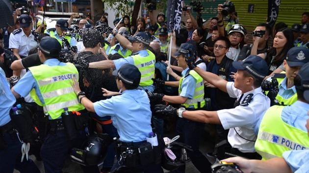 Hong Kong police use pepper-spray as a fight breaks out between pro-democracy protesters who were carrying a mock coffin and another man early morning in the Wanchai district in Hong Kong. The unrest in Hong Kong illustrated the challenges faced by China, which is also contending with US trade war negotiations. (Nicolas Asfouri / AFP)