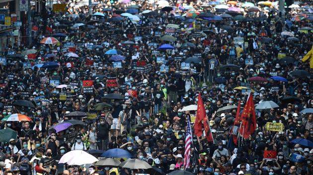 People take part in a march in the Causeway Bay shopping district in Hong Kong. Running battles raged for hours across multiple locations, with some hardcore protesters hurling rocks and petrol bombs, while police responded for the most part with tear gas, rubber bullets and water cannon. (Mohd Rasfan / AFP)