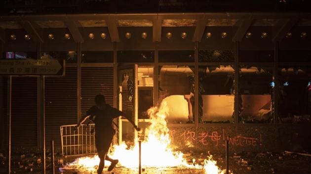 A protester runs after setting a government office building on fire in Hong Kong. (AP Photo) A protester runs after setting a government office building on fire in Hong Kong. (AP Photo)
