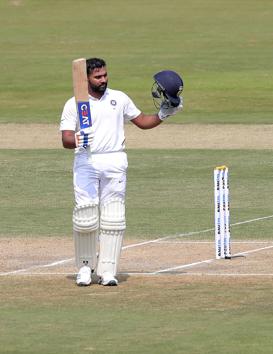 India's Rohit Sharma raises his bat after scoring hundred runs during the first day of the first cricket Test match against South Africa in Visakhapatnam (AP)
