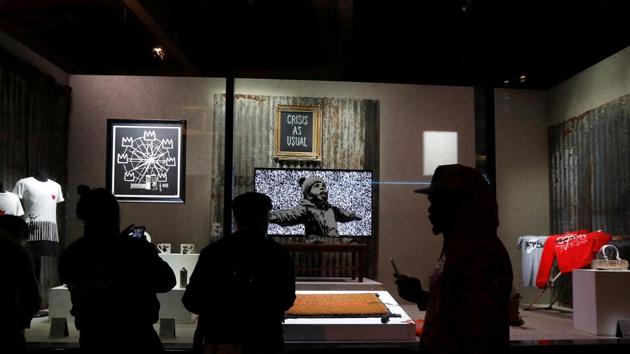 Original artworks by British artist Banksy form part of an installation inside a shop front. Other works on show include a baby’s crib underneath a mobile made of security cameras and a reimagining of breakfast cereal character Tony the Tiger as a rug. (REUTERS)