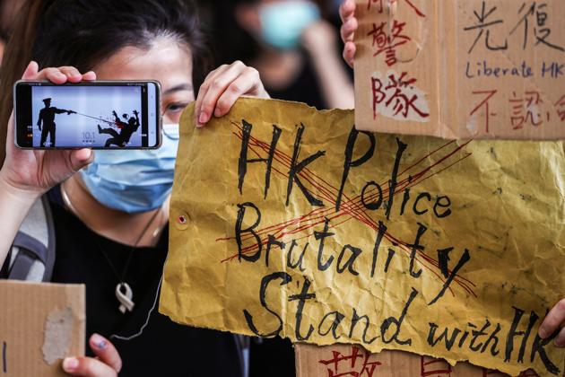 People hold up signs and a mobile phone as they gather at West Kowloon Law Courts Building to show their support to 96 anti-government protesters who were arrested days ago in Hong Kong, China, October 2, 2019(REUTERS)