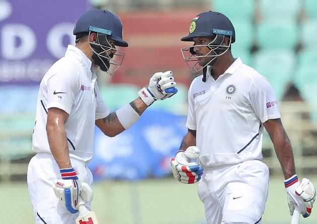 India's Mayank Agarwal, right, listens to captain Virat Kohli as they bat during the second day of the first cricket test match against South Africa in Visakhapatna. (AP)
