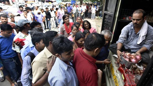 People stand in queue to buy onions sold at Rs 23.90 per kg by Delhi Government of India, outside Krishi Bhawan. Exports of all varieties of onions are now prohibited, the government said on Sunday. Devinder Sharma, a food and trade policy analyst in Punjab with 30 years of experience in food policies, says the government is panicking over surging onion prices. (Sonu Mehta / HT Photo)