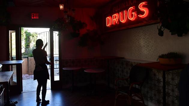 A waitress is silhouetted through a doorway at the cafe. “We’re enjoying the day, the music’s good, the weather’s good and we’re in California. Life can’t get better,” Kirschner added. (Frederic J. Brown / AFP)