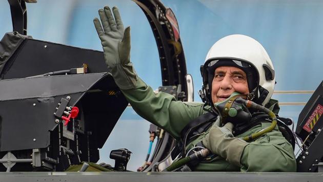 Union Defence Minister Rajnath Singh waves as he sits inside the cockpit of a light combat aircraft Tejas before a sortie at HAL airport in Bengaluru.(File photo: PTI)