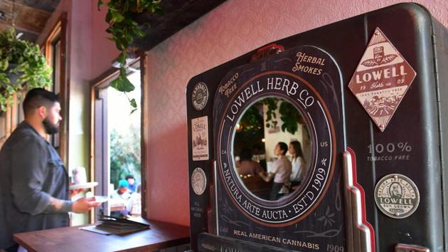 A server brings food from the indoor to outdoor setting at the Lowell Cafe. “Flower Hosts,” or “budtenders,” help patrons navigate the menu, giving advice to connoisseurs or novices on what strain of cannabis to order with their meal and the potency and flavour of each product. (Frederic J. Brown / AFP)