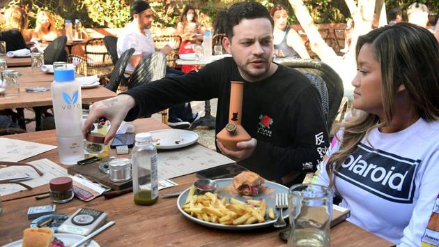 Will Halverson (L) prepares to smoke from bong next to Mimi Bui as they have a meal at Lowell Farms. In California, which has the world’s largest legal marijuana market, recreational pot became legal in 2018, setting off a mad rush by entrepreneurs to cash in on the multi-billion-dollar industry. (Frederic J. Brown / AFP)
