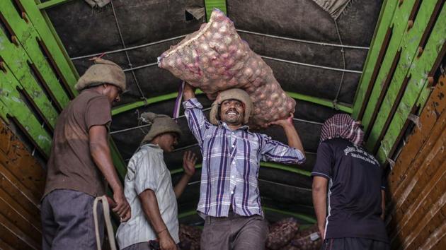 Workers unload sacks of onions from trucks at APMC wholesale market. The onion, whose soaring prices have been blamed for bringing down past governments, puts Prime Minister Narendra Modi in a tight spot. During his re-election campaign this year, the premier promised to raise incomes for farmers, a key voting constituency that makes up more than half of the electorate. Yet Modi also needs to ensure inflation remains stable, and food prices are already spiking higher. (Dhiraj Singh / Bloomberg)
