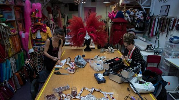 Women work inside a workshop at Moulin Rouge. Every time a number finishes out on stage, the troupe of dancers rushes backstage. There, the multicoloured costumes, many encrusted in rhinestones, have been laid out in order by an army of assistants. Rows of pink feather boas hang from rails. (Philippe Wojazer / REUTERS)