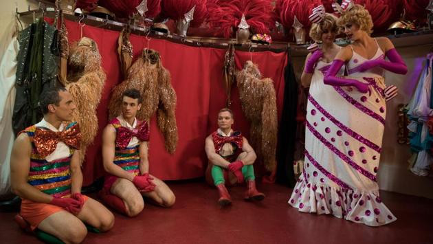 Dancers Claudiu, Harry, Reece, Samantha and Claudine seen backstage. The costumes of the dancers are changed by assistants in an instant. Then, the troupe rush back out onstage into the glare of the footlights. Without a pause, the assistants backstage put away the outfits that the dancers removed, then lay out a new set of outfits so they are ready for the next costume change and the next number. (Philippe Wojazer / REUTERS)