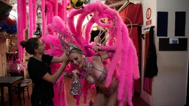 Dancer Megan changes costume as she performs in the review Feerie. Backstage – unseen by the 6,00,000 audience members who watch the show each year and quaff their way through nearly a quarter of a million bottles of champagne – is a different kind of choreography; the sophisticated machinery of costume changes and scenery-pulling needed to make the show happen. (Philippe Wojazer / REUTERS)