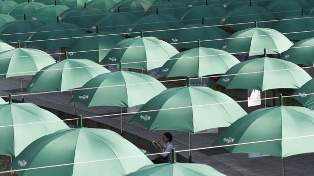 A woman reads a book under the umbrellas on display over Cheonggye stream during a campaign to raise money donation to help underprivileged children in Seoul, South Korea. (Ahn Young-joon / AP)