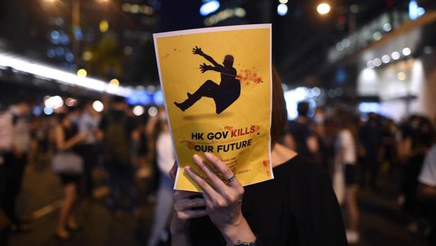 A woman holds up a handbill as protesters gather in the street in the heart of Hong Kong's commercial district Central the government announced a ban on face masks. Hong Kong's leader invoked colonial-era emergency powers on October 4 to ban protesters wearing face masks, but the move aimed at quelling months of unrest sparked immediate fresh rallies and vows to defy the new law. (Mohd Rasfan / AFP)