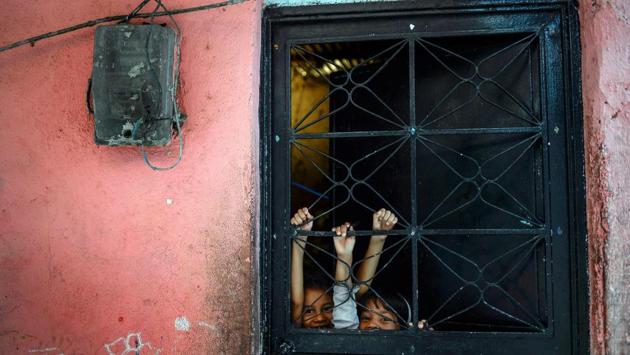 Children play behind the door, in Petare slum, in Caracas, Venezuela. (Matias Delacroix / AFP)