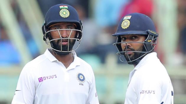 India's Rohit Sharma, right, and Cheteshwar Pujara stand in the field during the fourth day of the first cricket test match against South Africa in Visakhapatnam. (AP)