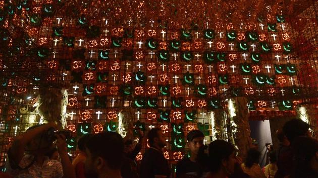 Depicting the oneness of all faiths, the 19th Durga Puja pandal at Beleghata 33 Pally has the theme ‘Amra Ek, Eka Noi’ (We are one, not alone). The creator Rintu Das has made the use of symbols from different religions in the pandal. (Samir Jana / HT Photo)