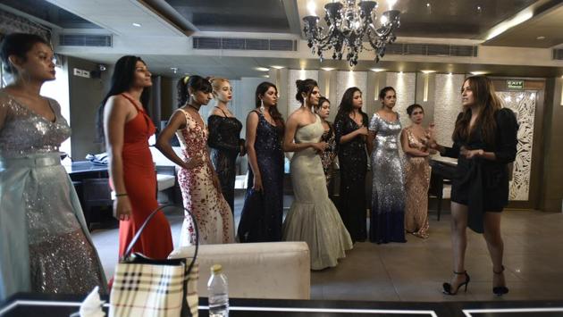 A woman briefs participants as they gear up to walk the ramp in gowns. The participants were attired in elegant collections designed by International Institute of Fashion Academy, Janakpuri. The participants were ranked on the basis of their behaviour, body language, confidence, personal interview, talent, etiquettes, fitness and knowledge. (Raj K Raj / HT Photo)