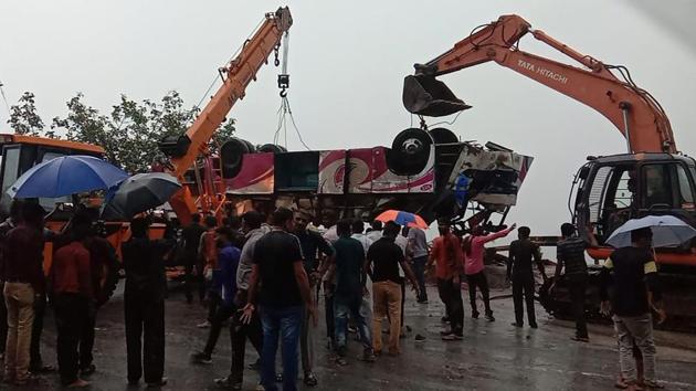 Machines lift a bus that flipped in an accident that killed 21 people returning from offering prayers near Ambaji temple in Anand district, some 175 kms from Ahmedabad, Gujarat with heavy rains hindering rescuers. (AFP)