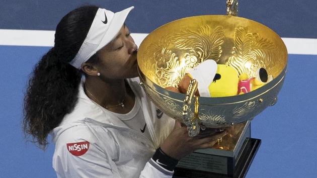 Naomi Osaka kisses her winner's trophy after defeating Ashleigh Barty in the women's final at the China Open.(AP)