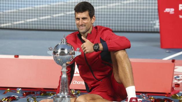 Novak Djokovic poses with his champion trophy during the award ceremony of the Japan Open.(AP)