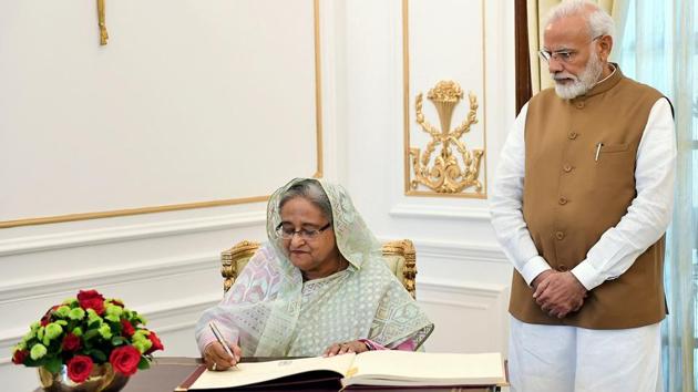 Prime Minister Narendra Modi looks on as his Bangladeshi counterpart Sheikh Hasina signs the visitors’ book at Hyderabad House, in New Delhi. (PTI)